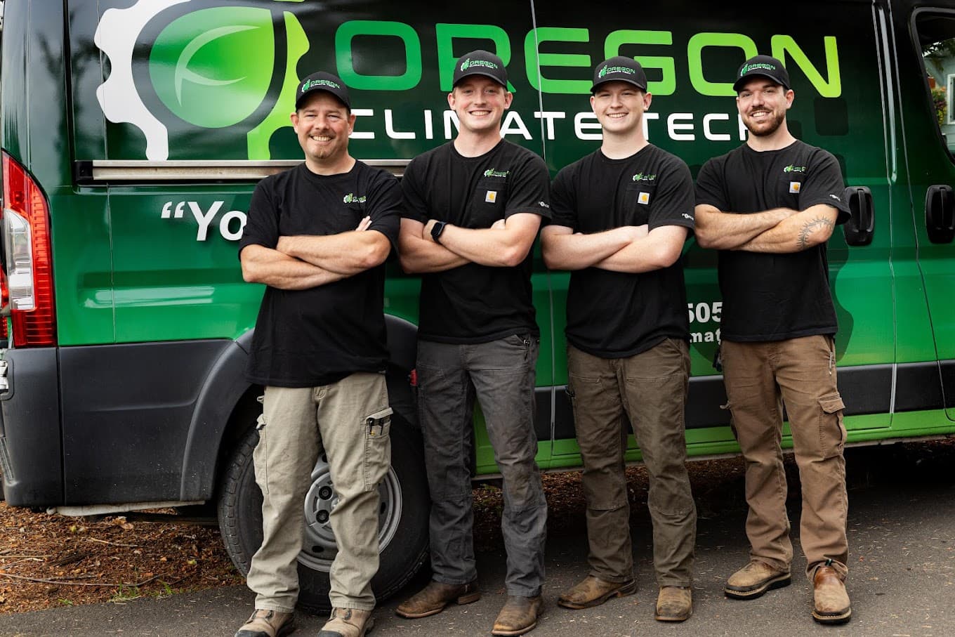 Four Oregon Climate Tech team members standing in front of a branded company van.